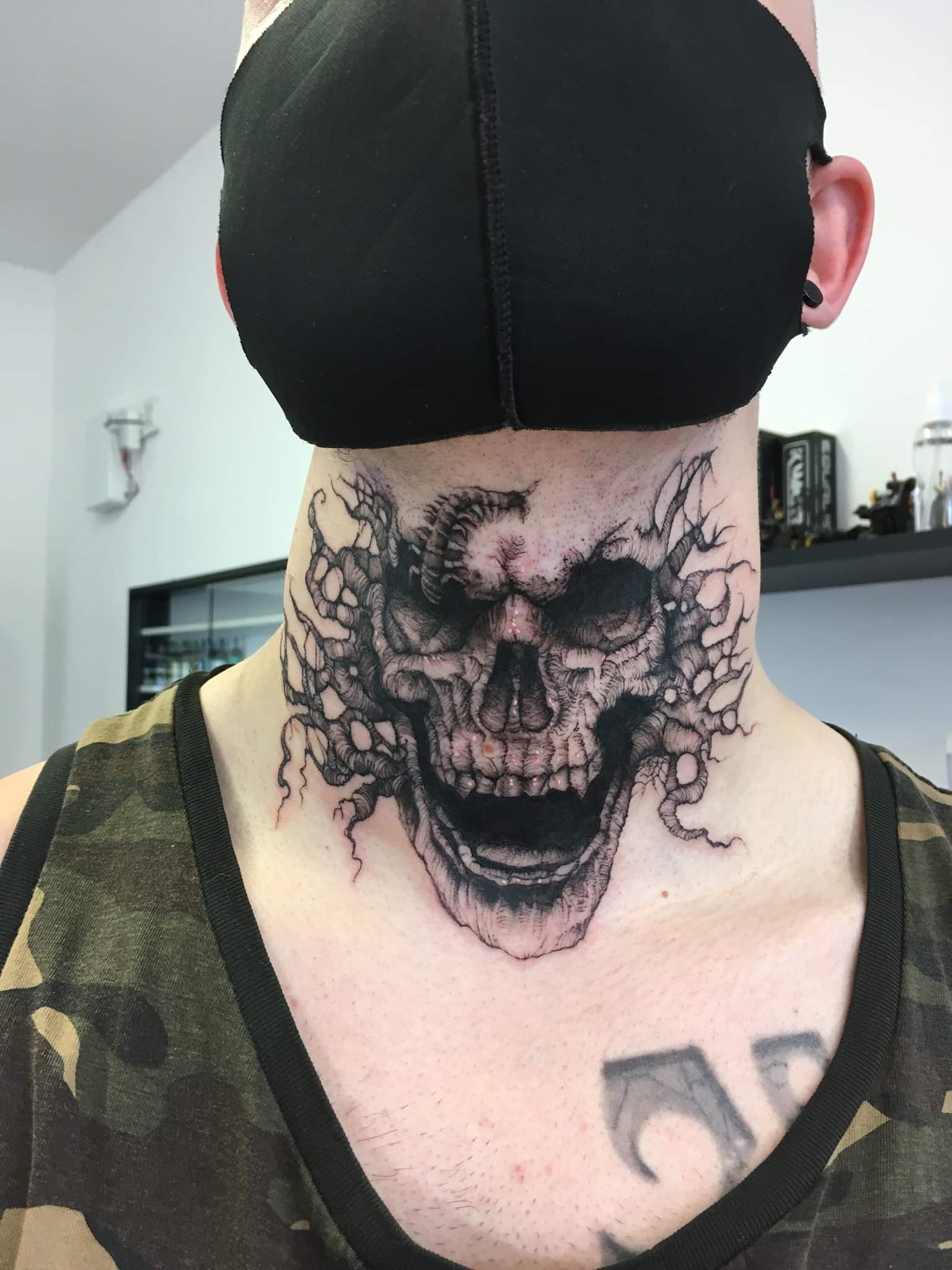 artistic neck tattoos for men with skull themes