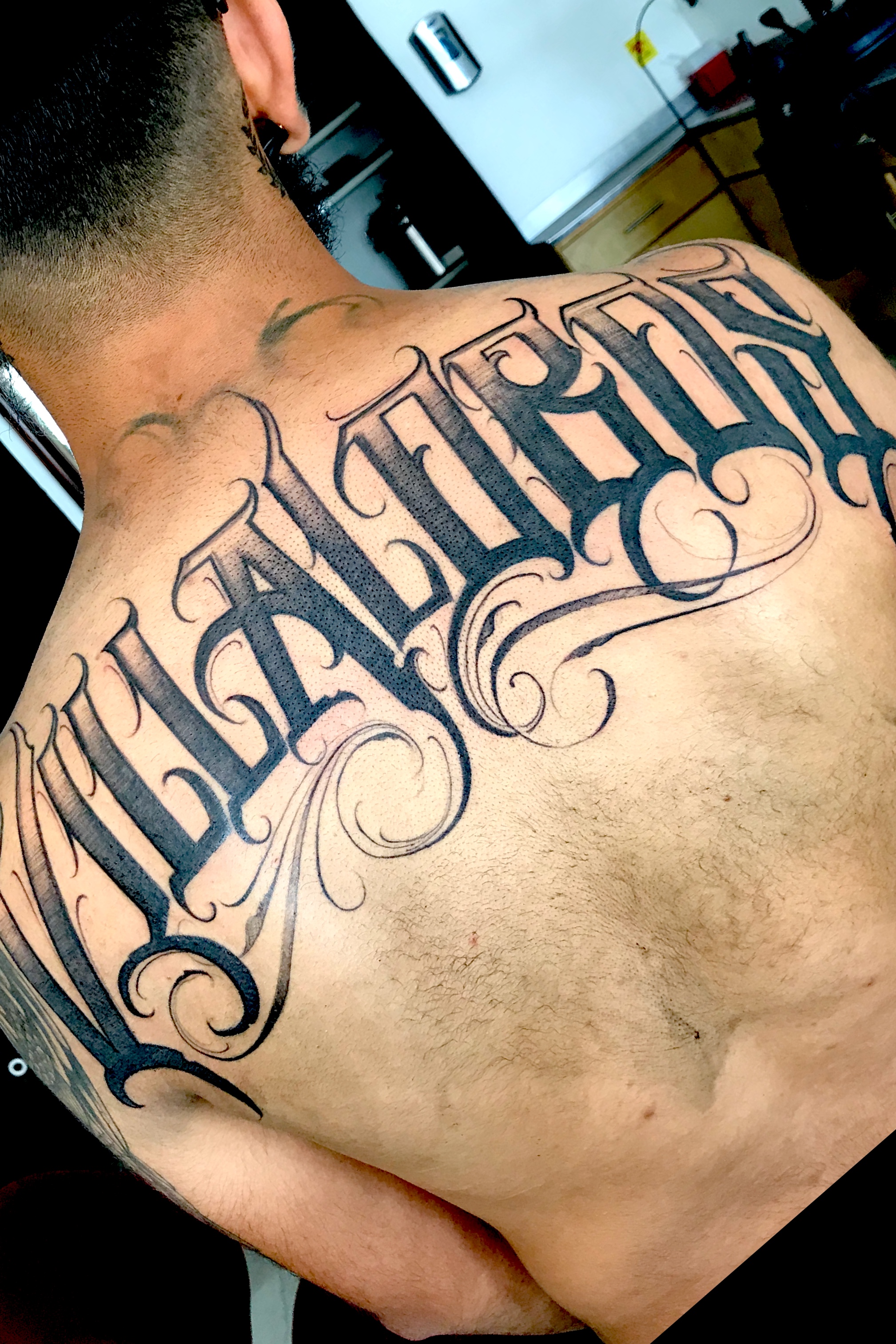 last name back tattoos for men symbolism