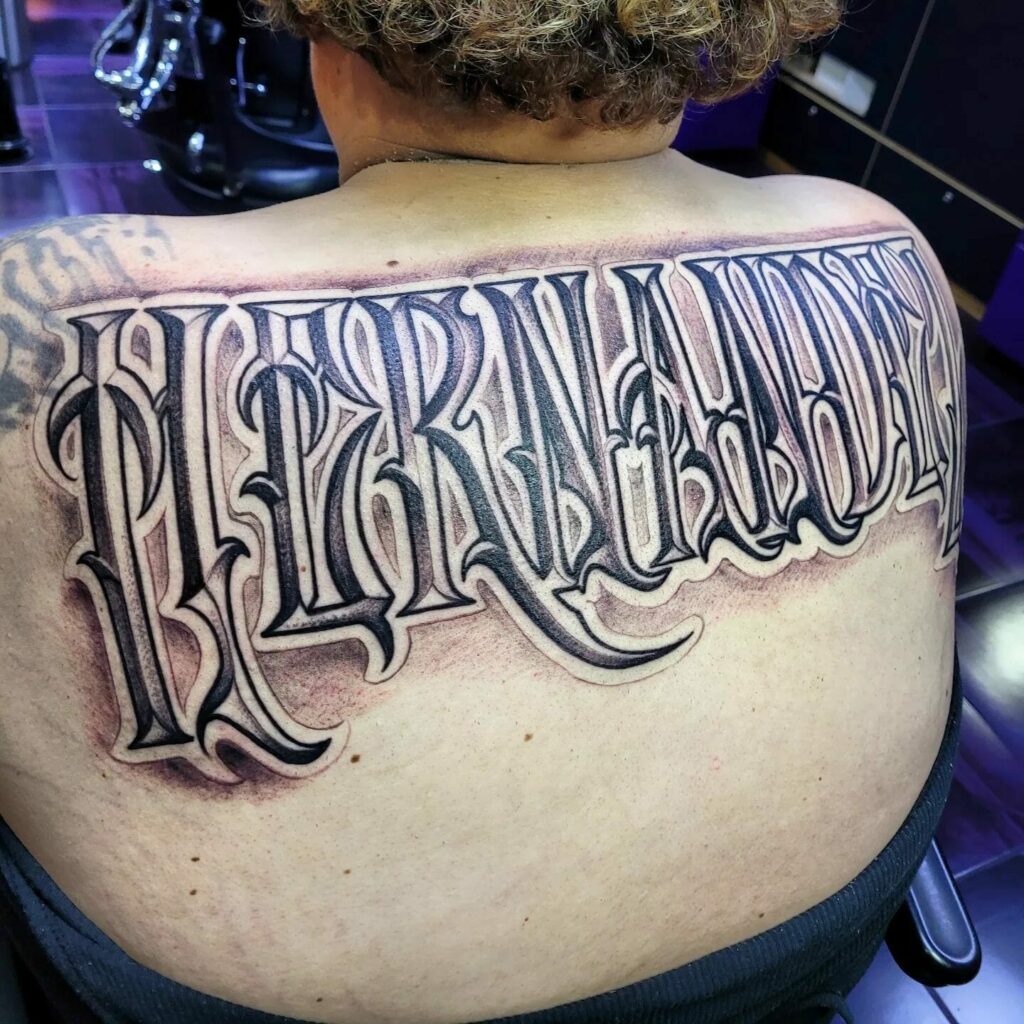 modern last name back tattoos for men.